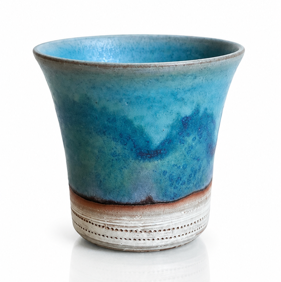 Handmade Japanese yunomi tea cup with blue Yohen glaze inspired by ocean waters.