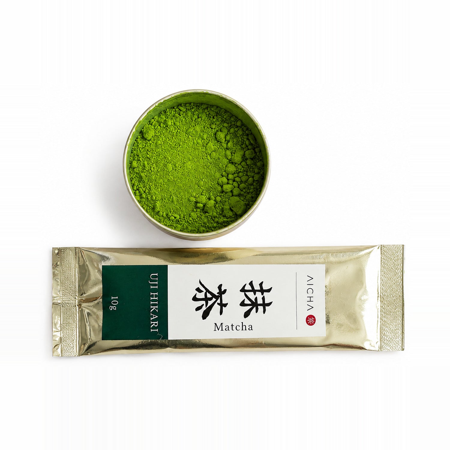 AiCha Single-Origin Ujihikari matcha — 10 g gold sachet beside a tin of vivid green matcha powder