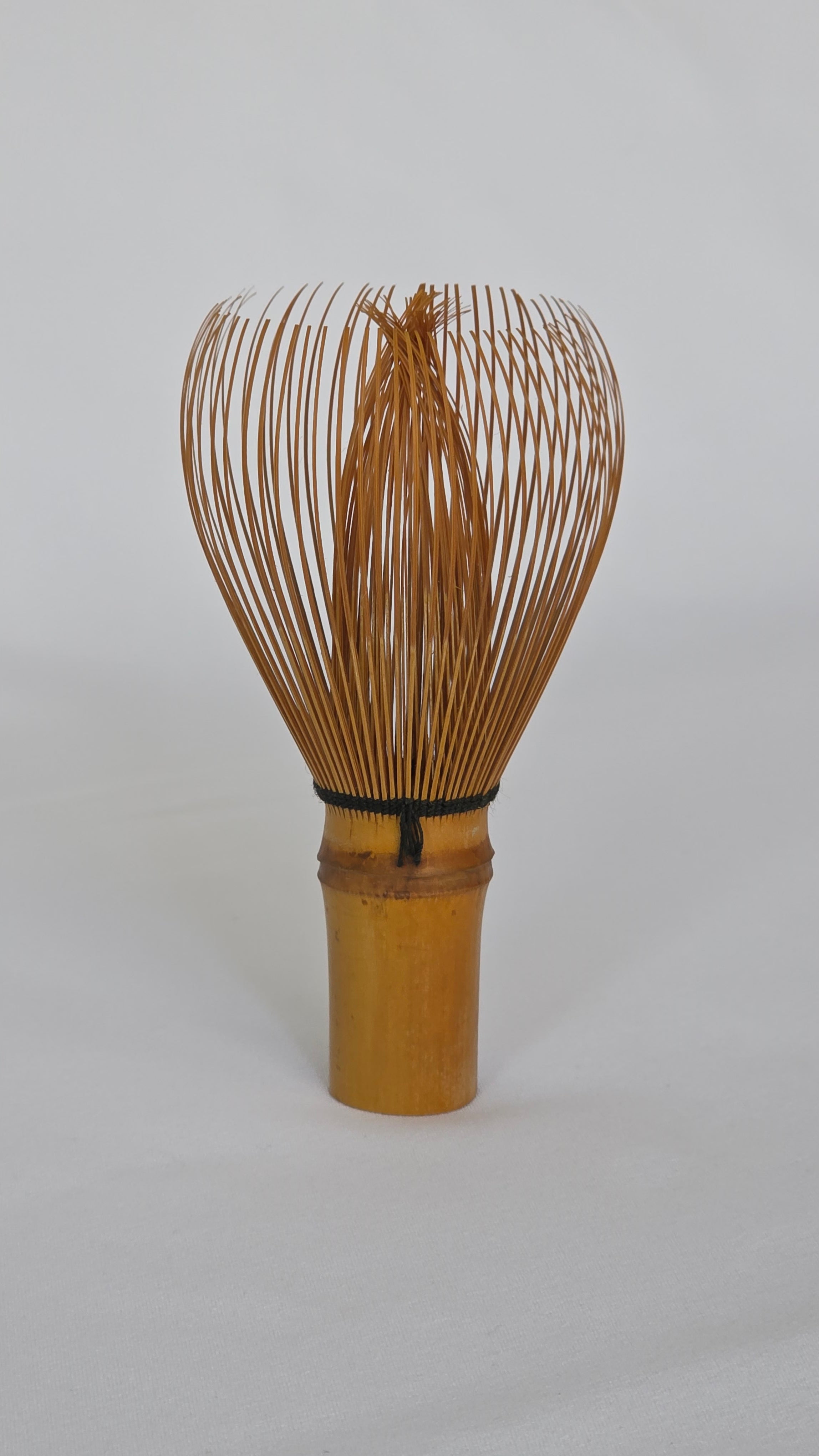 Chasen No. 119 handmade Japanese matcha whisk in golden bamboo, full side view showing the tall urn-shaped head
