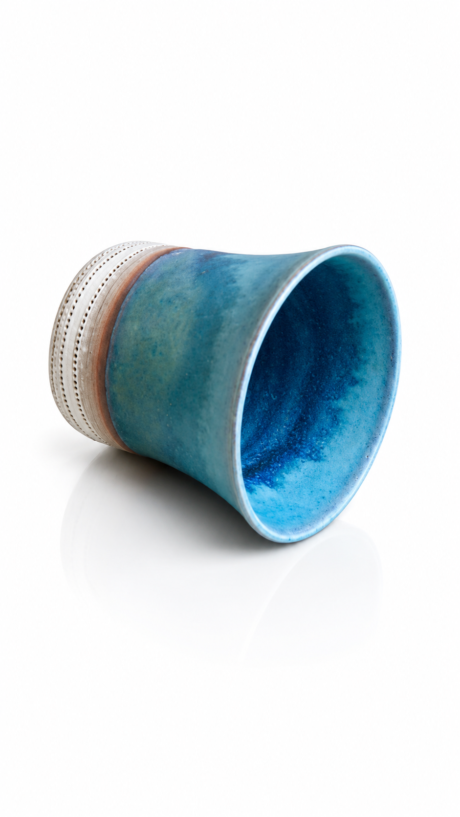 Japanese ceramic yunomi tea cup featuring ocean-blue glaze and hand-carved decorative detailing.